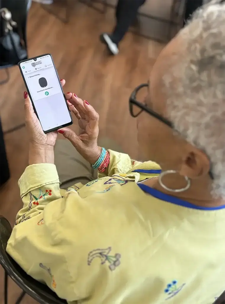 Lady looking at her phone which displays theSilent Beacon App