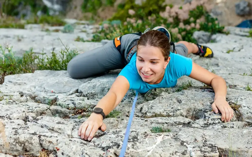 Woman wearing the Silent Beacon panic button on her wrist while rock climbing.