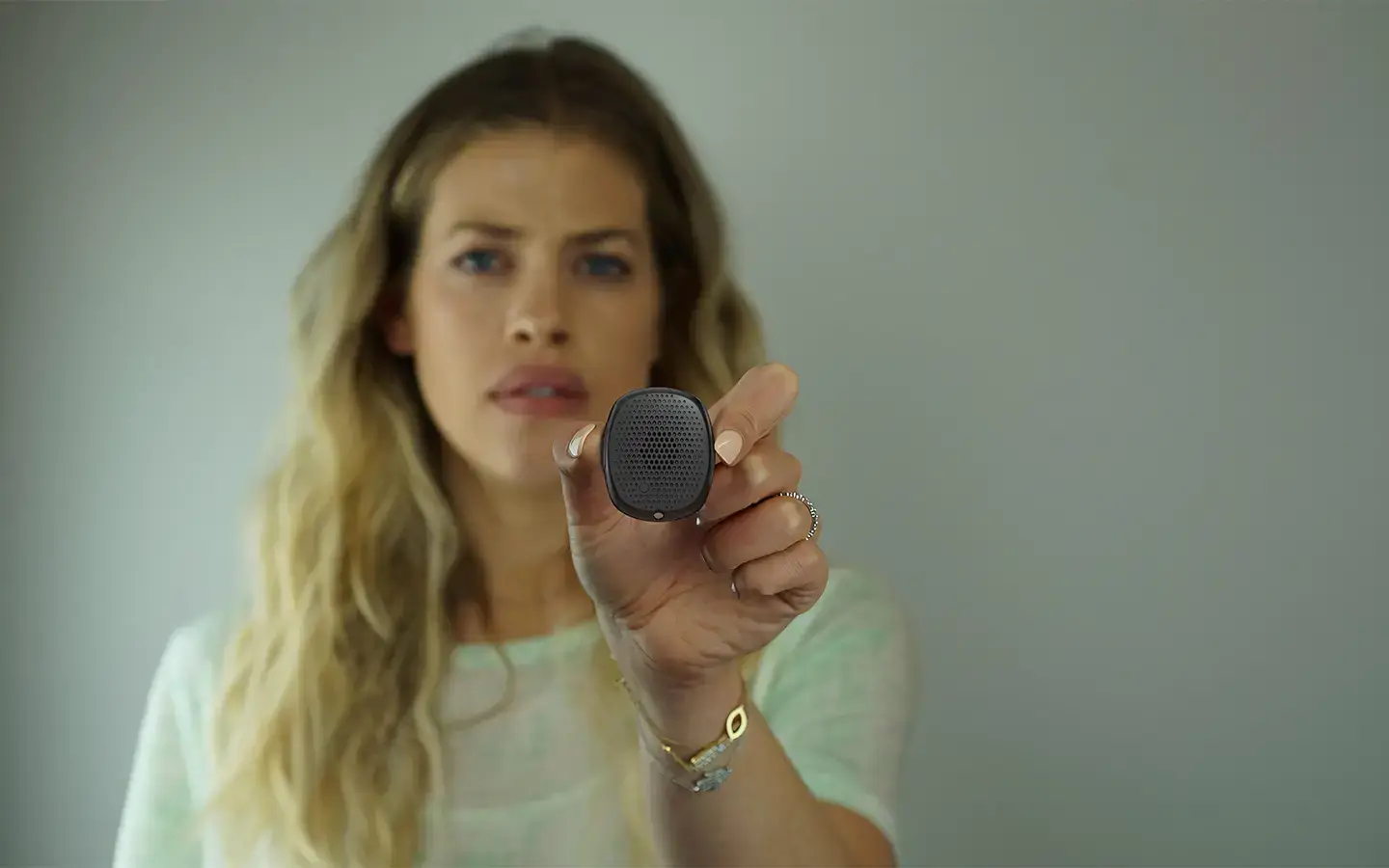 Woman holding Silent Beacon personal safety device up in a close-up.