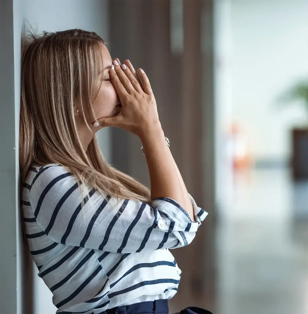 Woman experiencing burnout in hallway