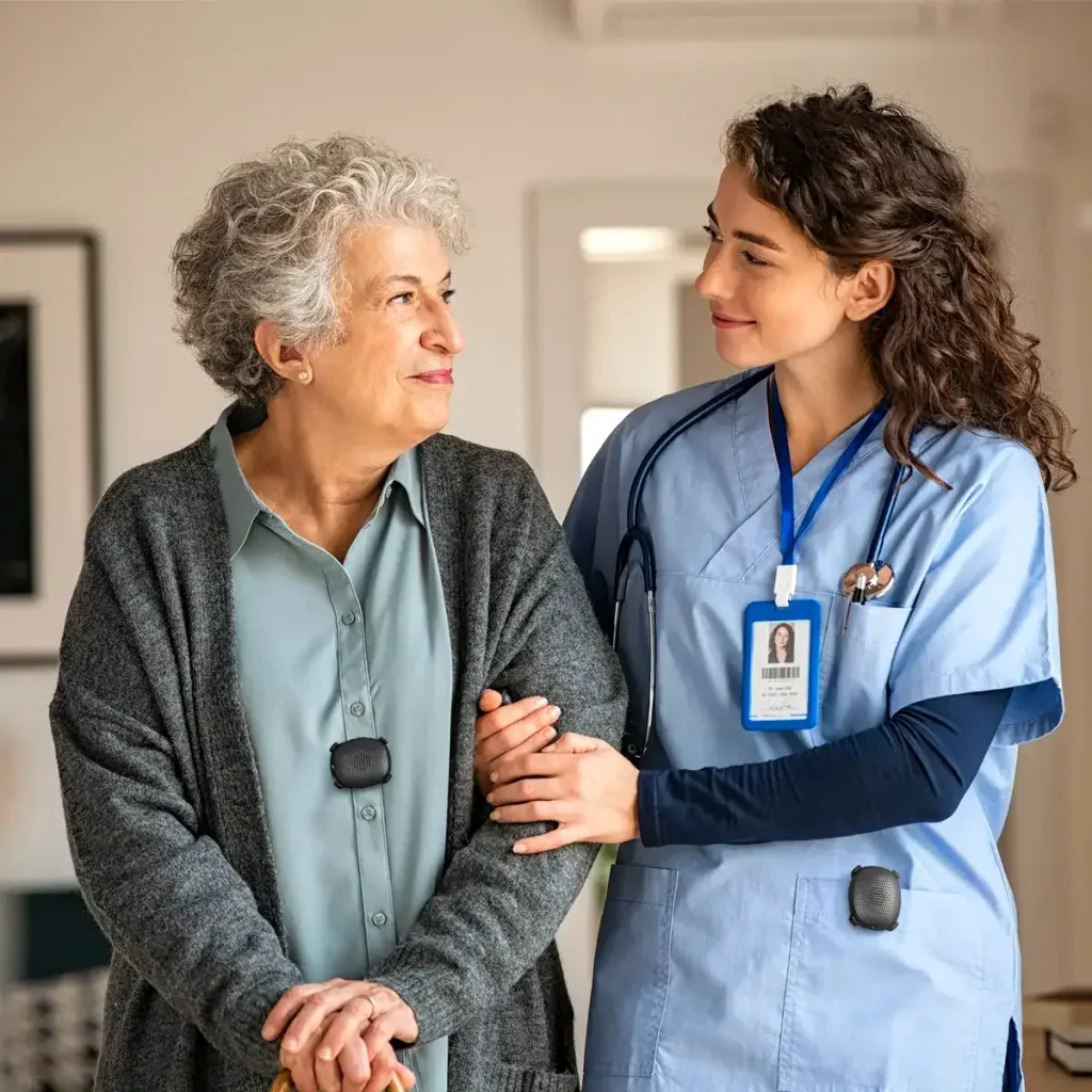 Nurse walking alongside a senior patient while both wear panic button devices to support safety, communication, and emergency preparedness.