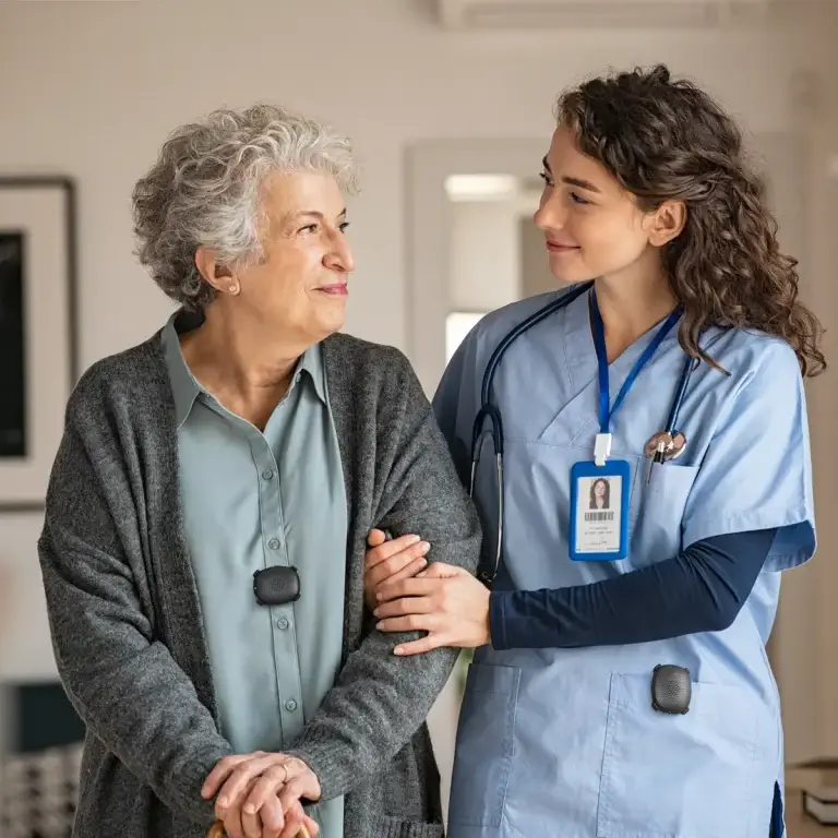 Nurse assisting an elderly patient, wearing a Silent Beacon panic button for hands-free, immediate emergency alerts.
