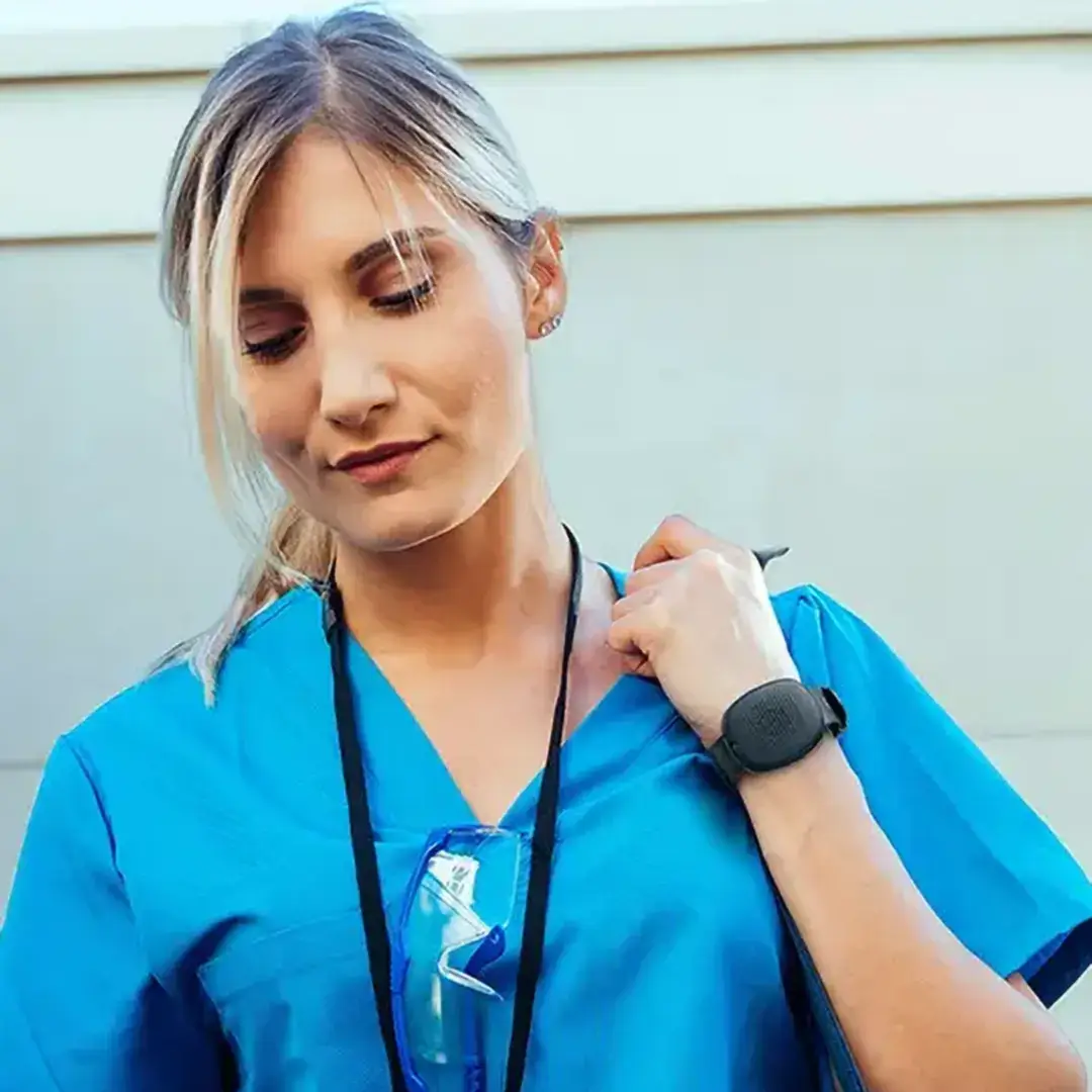 A travel nurse wearing a Silent Beacon device, which shows as activated, to enhance their safety and peace of mind.