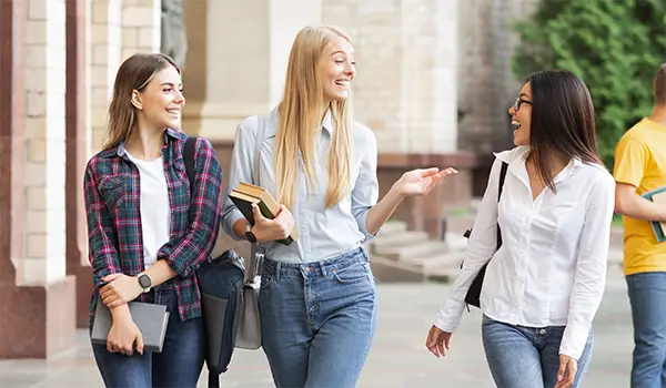 College students wearing Silent Beacon panic buttons while walking together on a university campus.